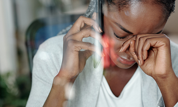 Sick pay entitlement: an unwell-looking nurse makes a call on her mobile phone 