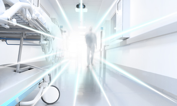 Paranormal encounters: illustration showing a ghostly figure walking beside a hospital bed in a corridor