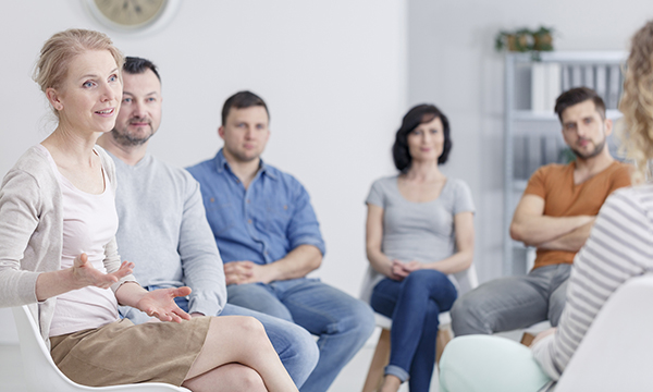 People sit round in some kind of collaborative group session