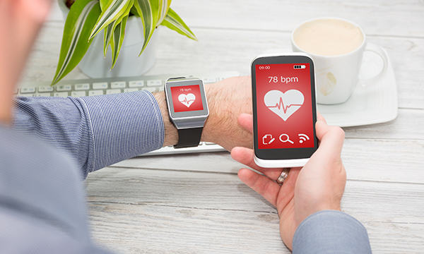 Someone monitoring a healthcare diagnostic app plugged into their smartphone