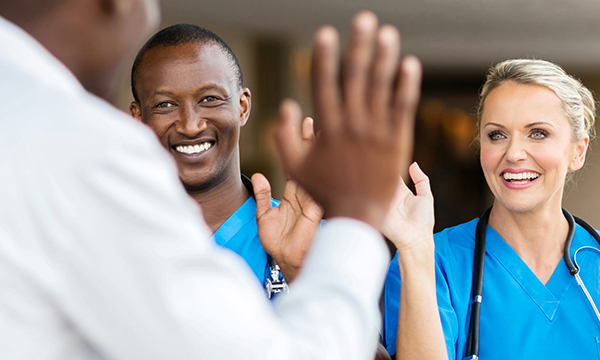 Two nurses waving goodbye to a colleague