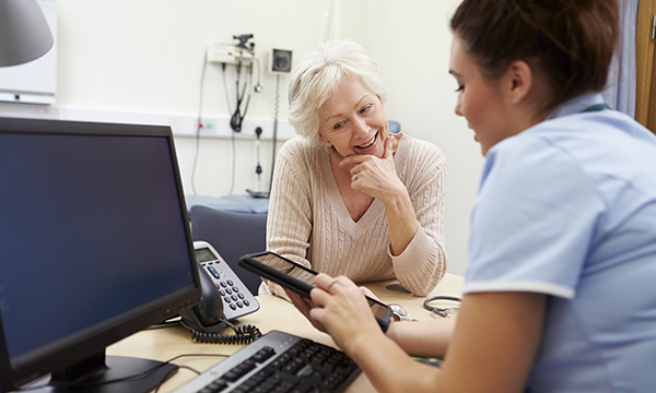 A nurse talking to a patient in an office