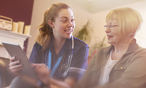 Nurse with iPad talking to patient