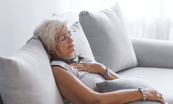 woman sits slumped on a sofa