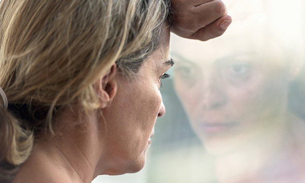 woman stares through window