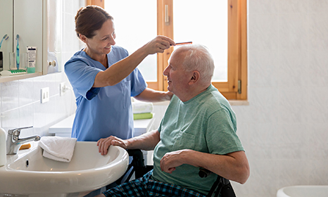 Nurse combing an older patient's hair