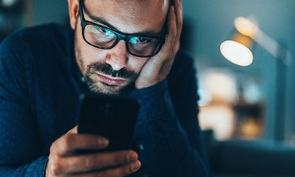 Man looking anxiously at phone