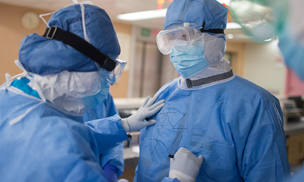 Head nurse Sun Chun, left, writes the name of her colleague Li Yunmo on her protective suit at the First Hospital of Wuhan City in Wuhan, central China's Hubei Province