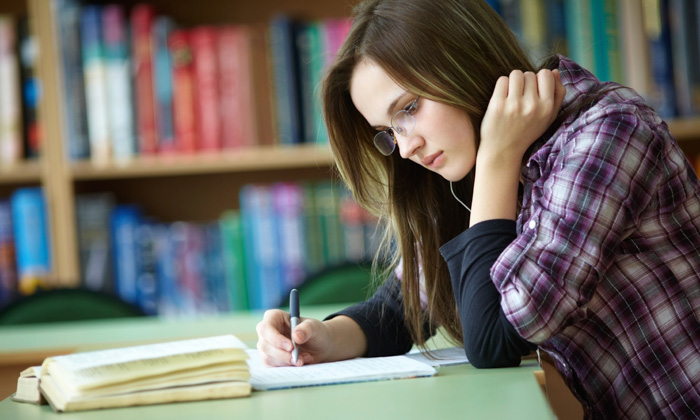 A woman in a library writing