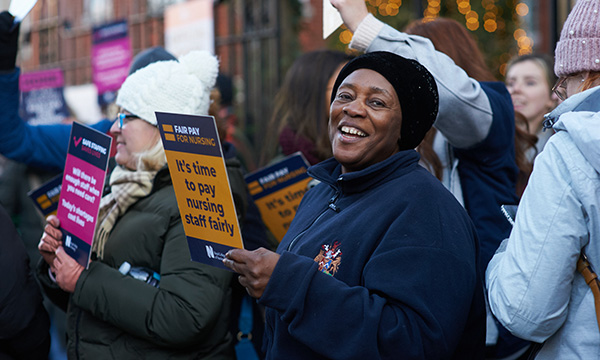 NHS striker smiles to the camera outside Royal Marsden in London