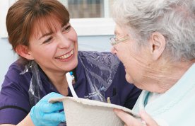 A nurse helps an elderly lady clean her teeth. Picture: Neil O'Connor