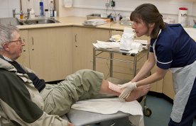 nurse care for man's leg wound in a practice setting