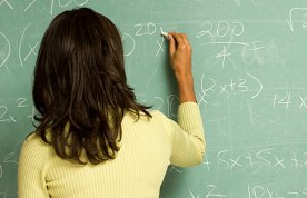 Woman undertaking maths calculation on a chalkboard
