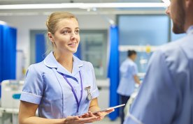 nursing student talks to colleague on a ward