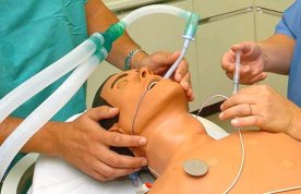 Nursing students learn how to insert and attach an oral tube into a manikin
