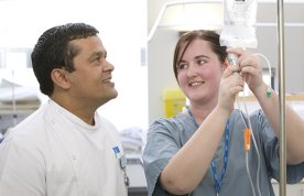 Nursing students learn intravenous (IV) infusion therapy administration from a registrant and assessor