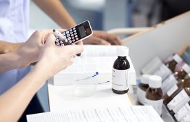 Drug calculations: a nurse using a calculator stands at a desk undertaking calculations for patient medications