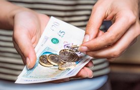 Nursing students facing money worries: someone counting cash in their hands, including a £20 note, a £5 note and five £1 coins