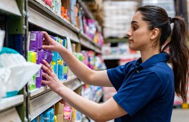 Nursing students working part-time in supermarkets: a young woman stacking shelves in a supermarket 