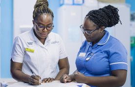 Success as a nursing student: a nursing student on clinical placement is supervised by a nurse while she completes paperwork on a ward