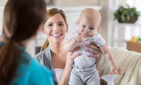 Woman holding up a new-born baby. Picture: iStock