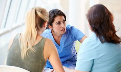 A nurse talks to a teenager moving to adult services and her mother