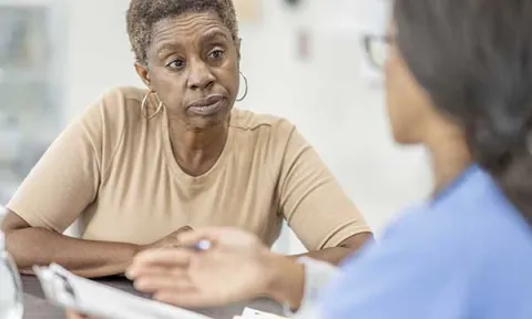 A nurse talks to a woman in the emergency department: skillful patient assessment forms the basis of triage