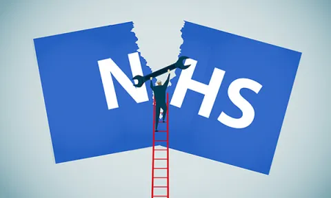 NHS in crisis: a man on a ladder tries to fix a torn NHS sign