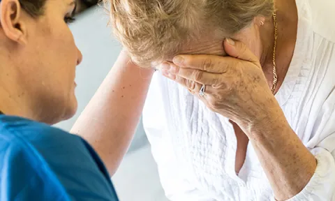 Breaking bad news: a nurse comforts a patient’s relative after breaking bad news about their care