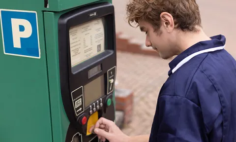 Holiday pay cuts and parking hikes: nurse paying for parking at meter