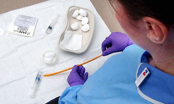 nurse prepares a catheter for insertion