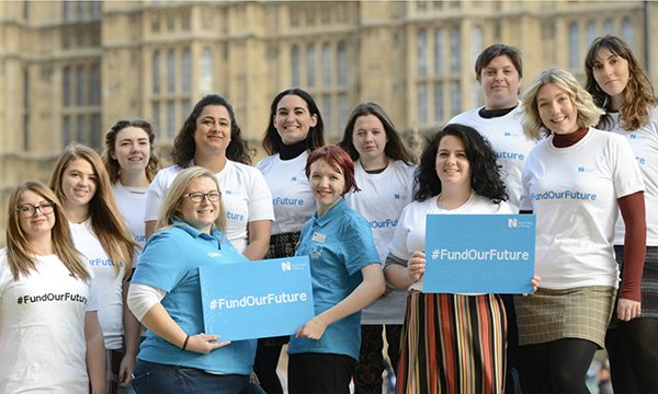 students hold 'fund our future' placards