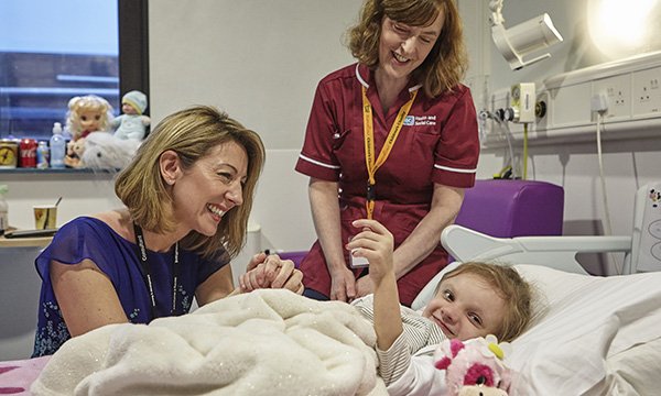 A Roald Dahl specialist children’s nurse with a patient and another healthcare team member