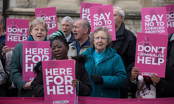 Anti-abortion demonstrators display banners from the Be Here for Me group