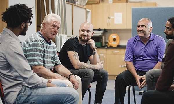 Image shows adult service users in a group support meeting