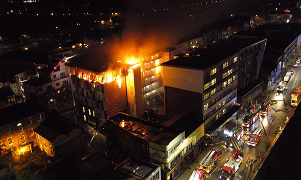 Picture shows the burning building in Bolton from which students were evacuated, with fire engines in a nearby street. Members of the nursing community have rallied round to help those affected.