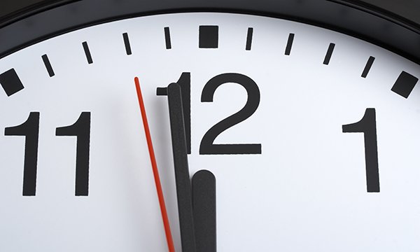 Top portion of clock face with the hands showing a minute to 12