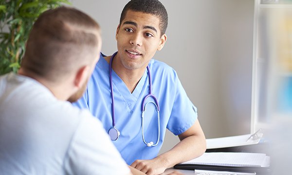young nurse, who is a man, in consultation with a patient