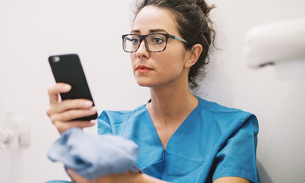 A nurse dialling a mobile phone. The helpline is designed to support NHS staff during the COVID-19 outbreak. Picture: iStock
