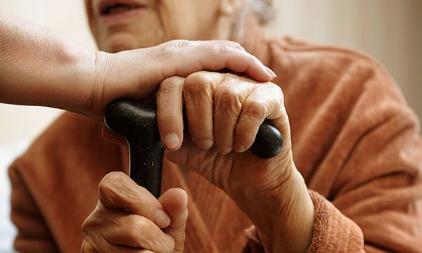 two people hands hold on to walking stick