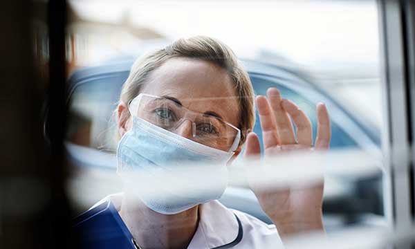 Community nurse greeting one of her patients on her rounds during the pandemic