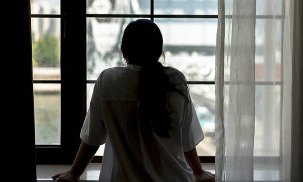 Woman standing looking out a window