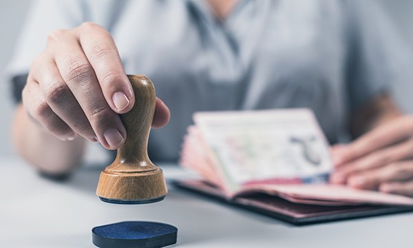 Picture shows someone about to stamp a passport
