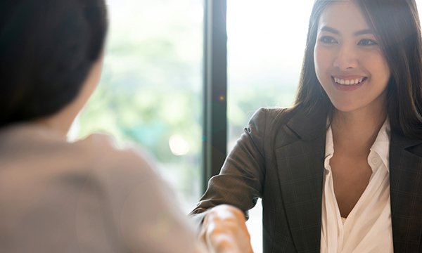 woman in a formal meeting shakes hands 