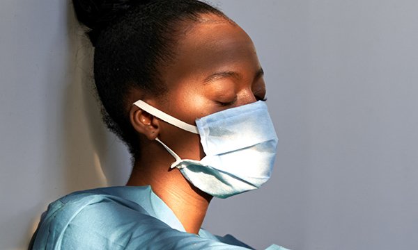 nurse looks exhausted as MPs call for better workforce planning to address nurse burnout