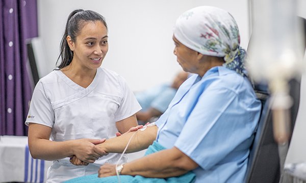 Nurse talks to patient receiving cancer treatment
