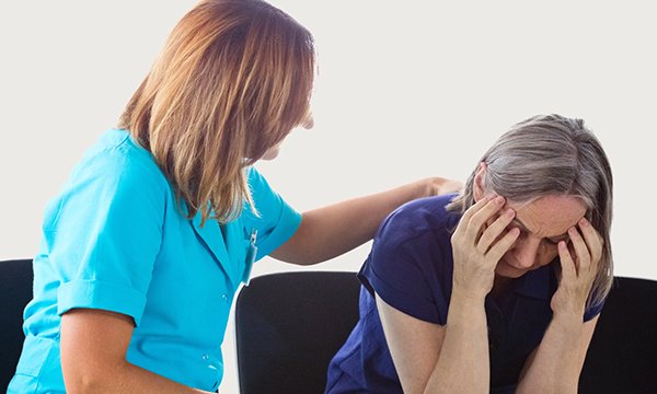 A woman comforts another who is showing signs of distress
