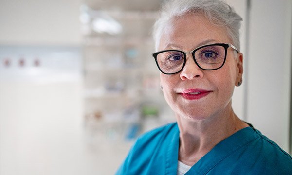 Picture shows an older woman in a nurse's outfit