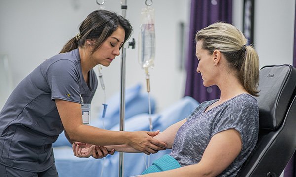 A nurse administering cytotoxic drugs to a patient: this would normally be done by nurses on at least band 6 level