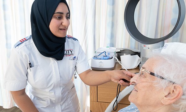 Photo of nursing student with a patient, illustrating story about students being called 'nurse' by patients